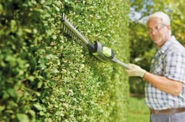 A Old man using Gtech Hedge Trimmer