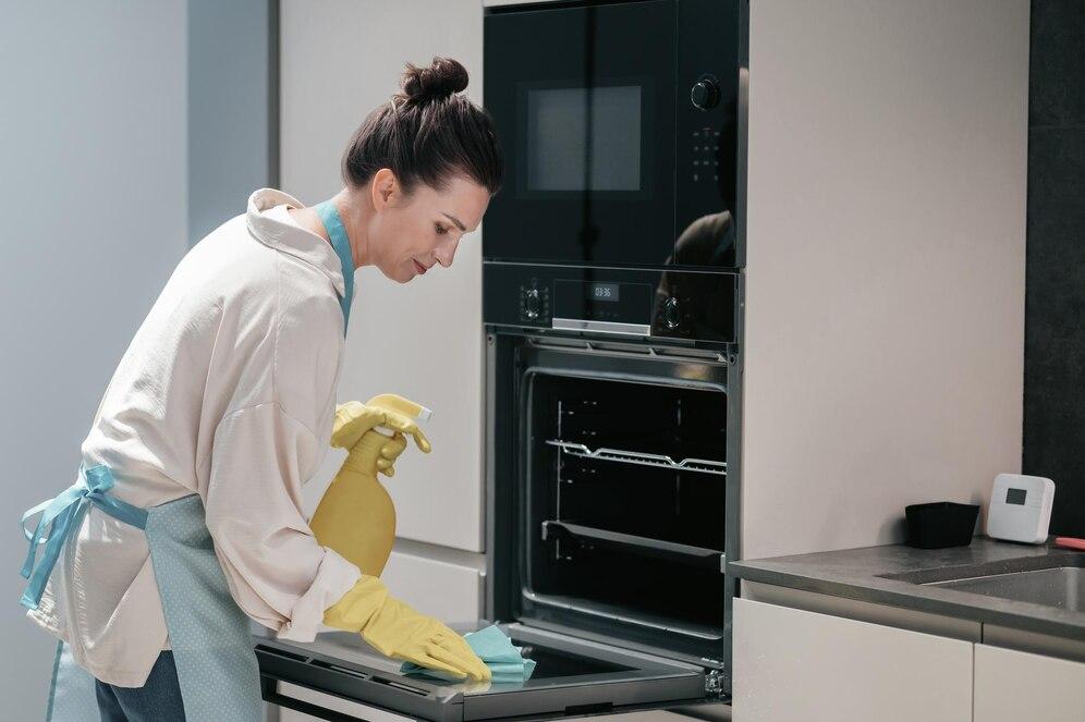 housewife in yellow gloves cleaning the kitchen